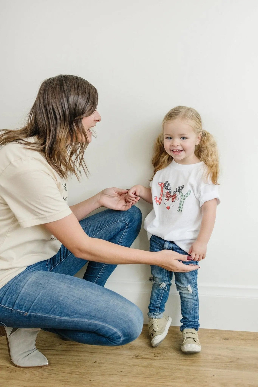 Child wearing a white kids t-shirt with colorful reindeer front graphic