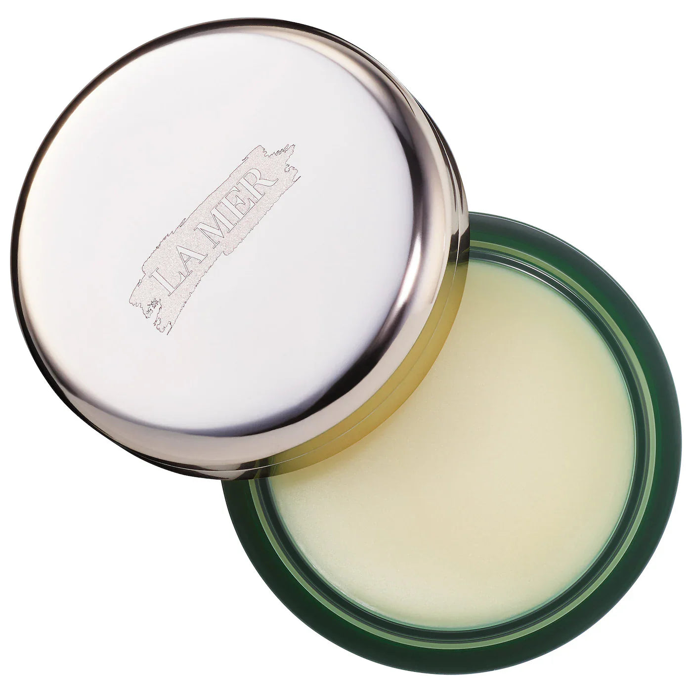 La Mer lip balm in open round metal tin, pale balm visible, green rim
