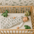 Light gray dinosaur-print sleep sack with zipper front, on sleeper