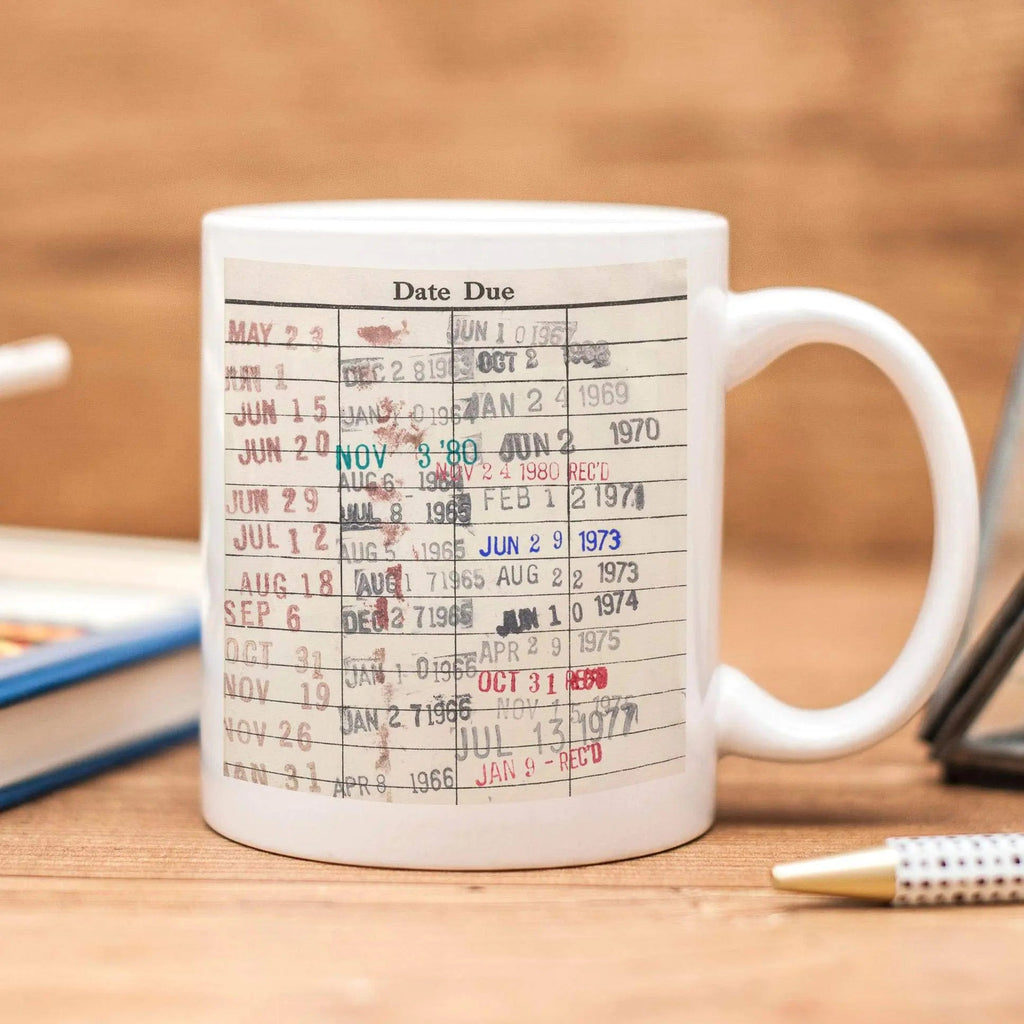 White coffee mug with colorful date-due calendar print and handle