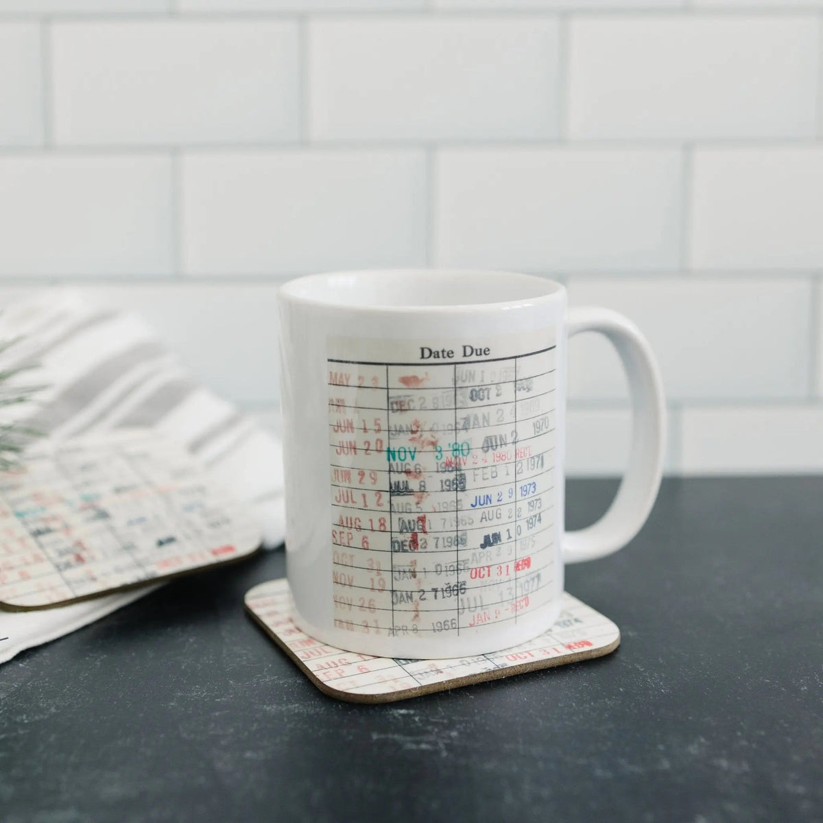 White coffee mug with date-due calendar print on matching coaster