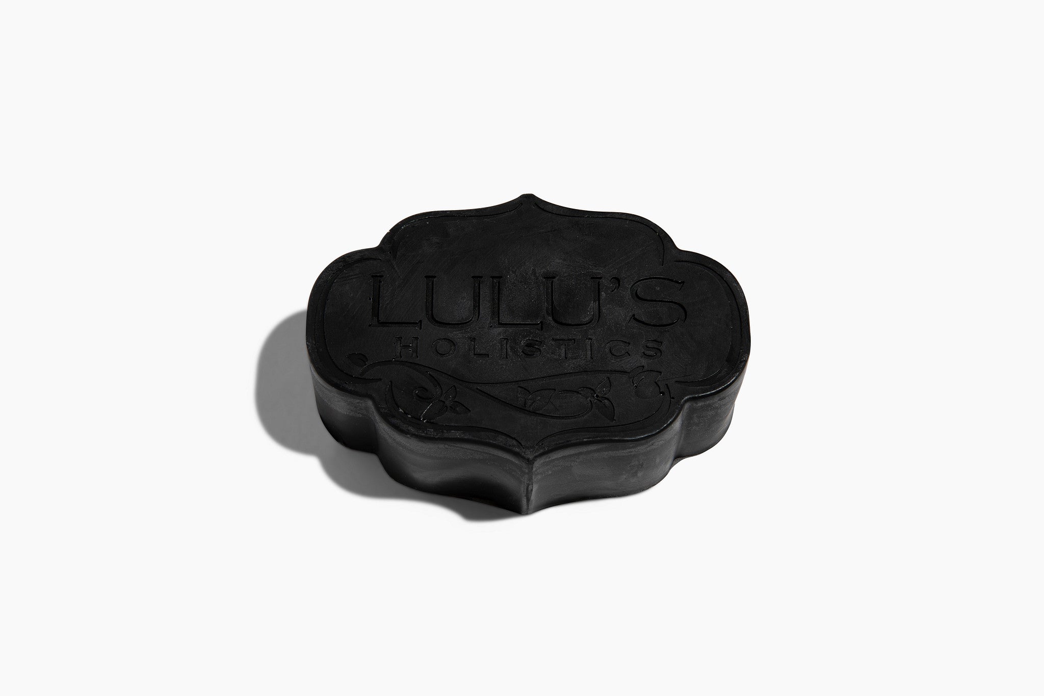 Flower-shaped glycerin bar soap, dark charcoal black with embossed LU LU's logo