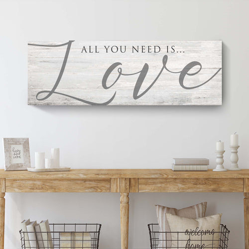Love wall canvas sign in landscape format with “All you need is…” and cursive “Love”