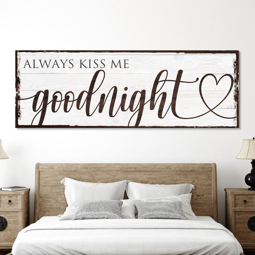 Framed wall art sign with "goodnight" script and heart above bed pillows