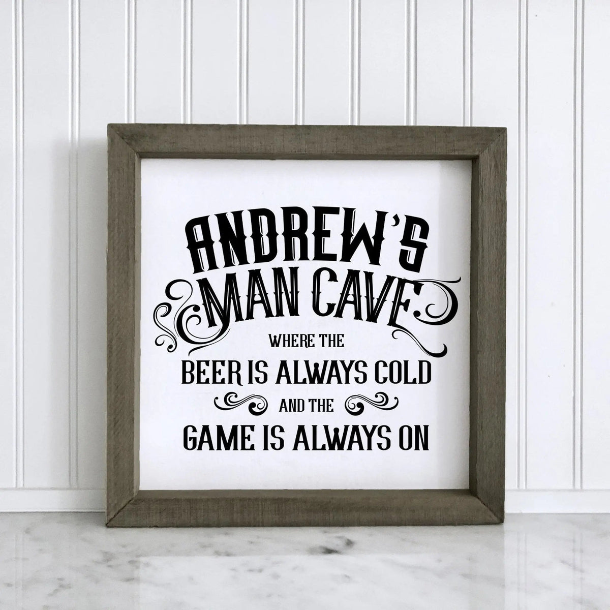 Personalized wood framed sign reading "ANDREW'S MAN CAVE" and "BEER IS ALWAYS COLD"