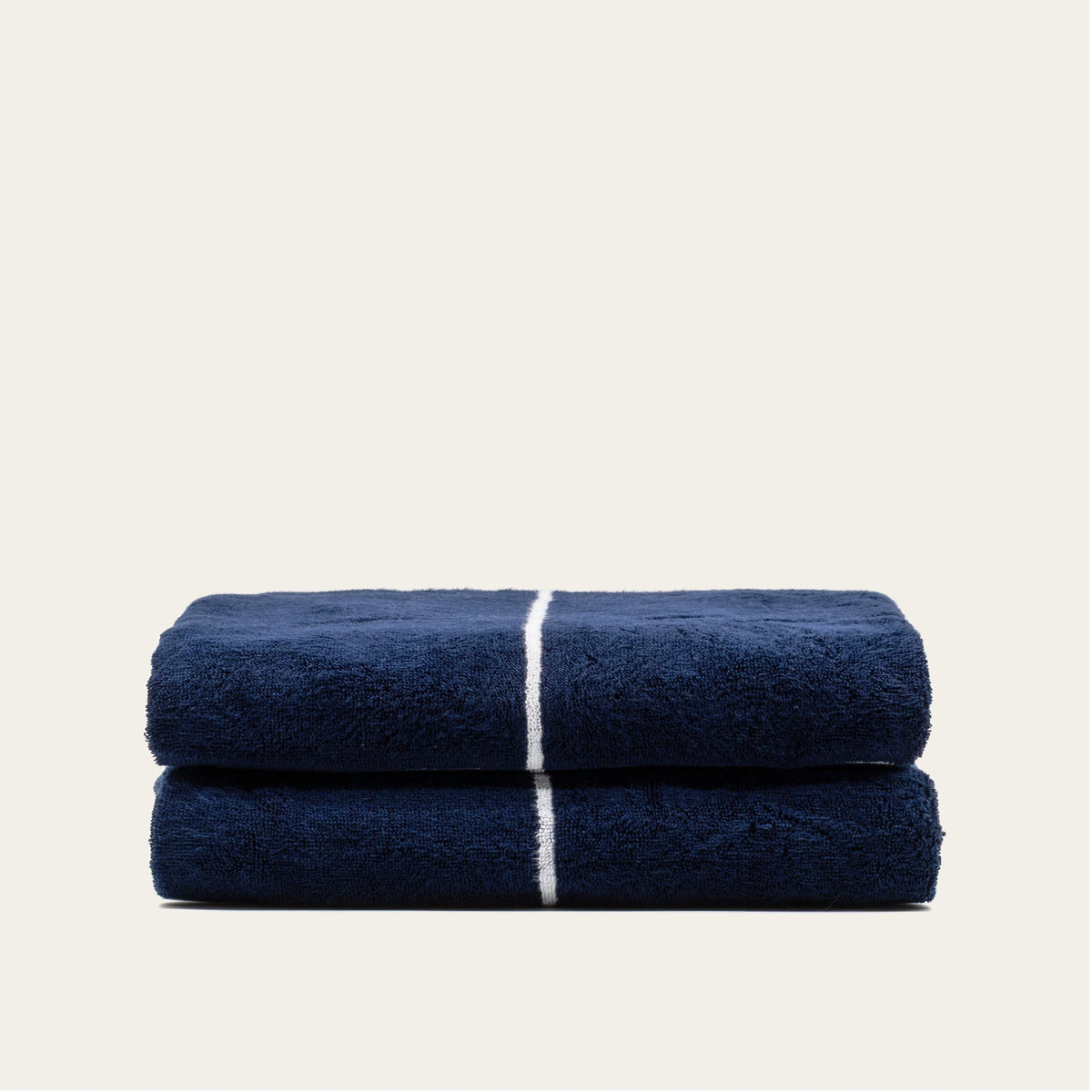 Folded navy cotton towels with white center stripe, stacked set of 2