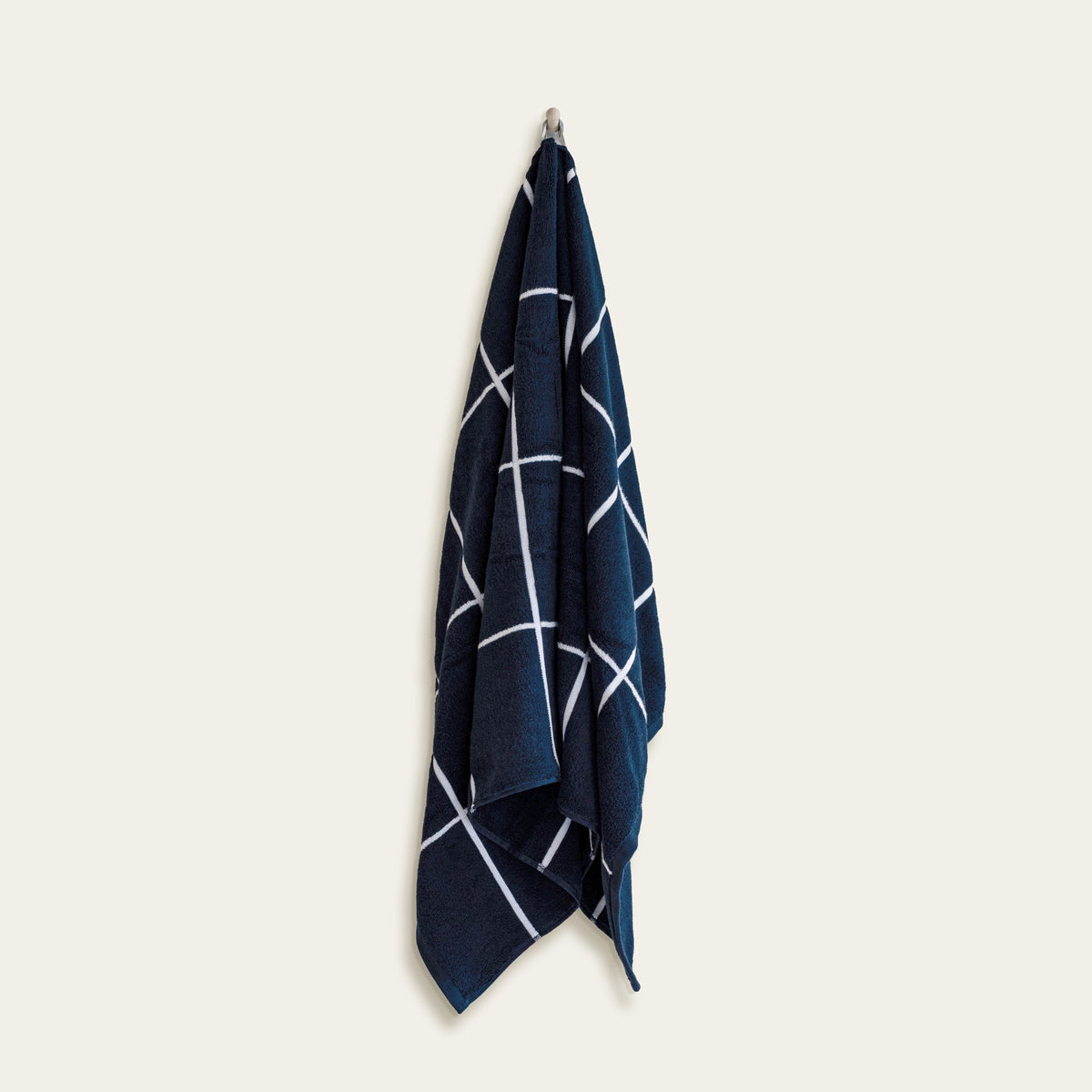 Hanging navy cotton towel with intersecting white line pattern