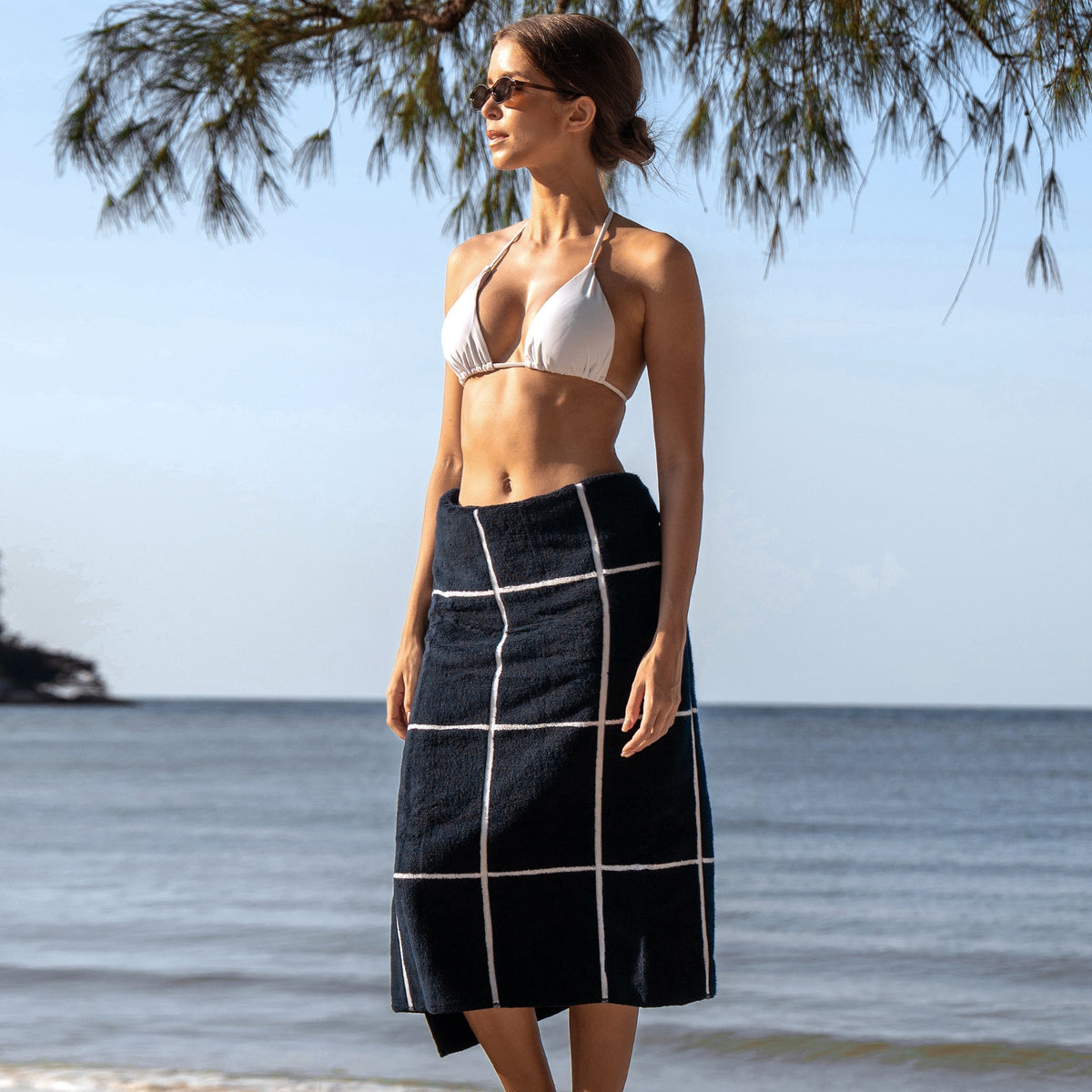 Navy and white grid cotton towel wrap with fringe hem, worn as a cover-up