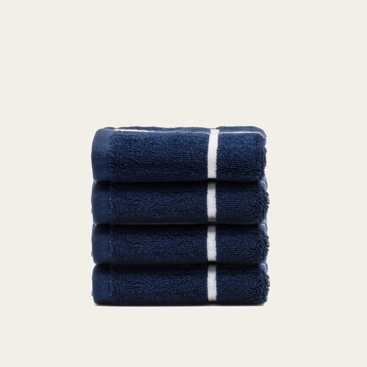 Navy cotton towel set with white stripe bands, folded into a compact stack