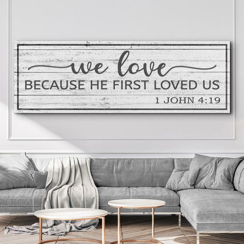 Framed landscape canvas wall art with 'we love' script and 'Because He First Loved Us' text