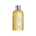 Molton Brown Flora Luminare bath and shower gel bottle, gold liquid, silver cap
