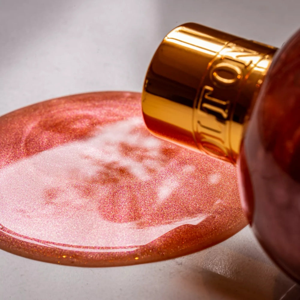 Bath & shower gel dispensing into pink foamy lather from gold cap
