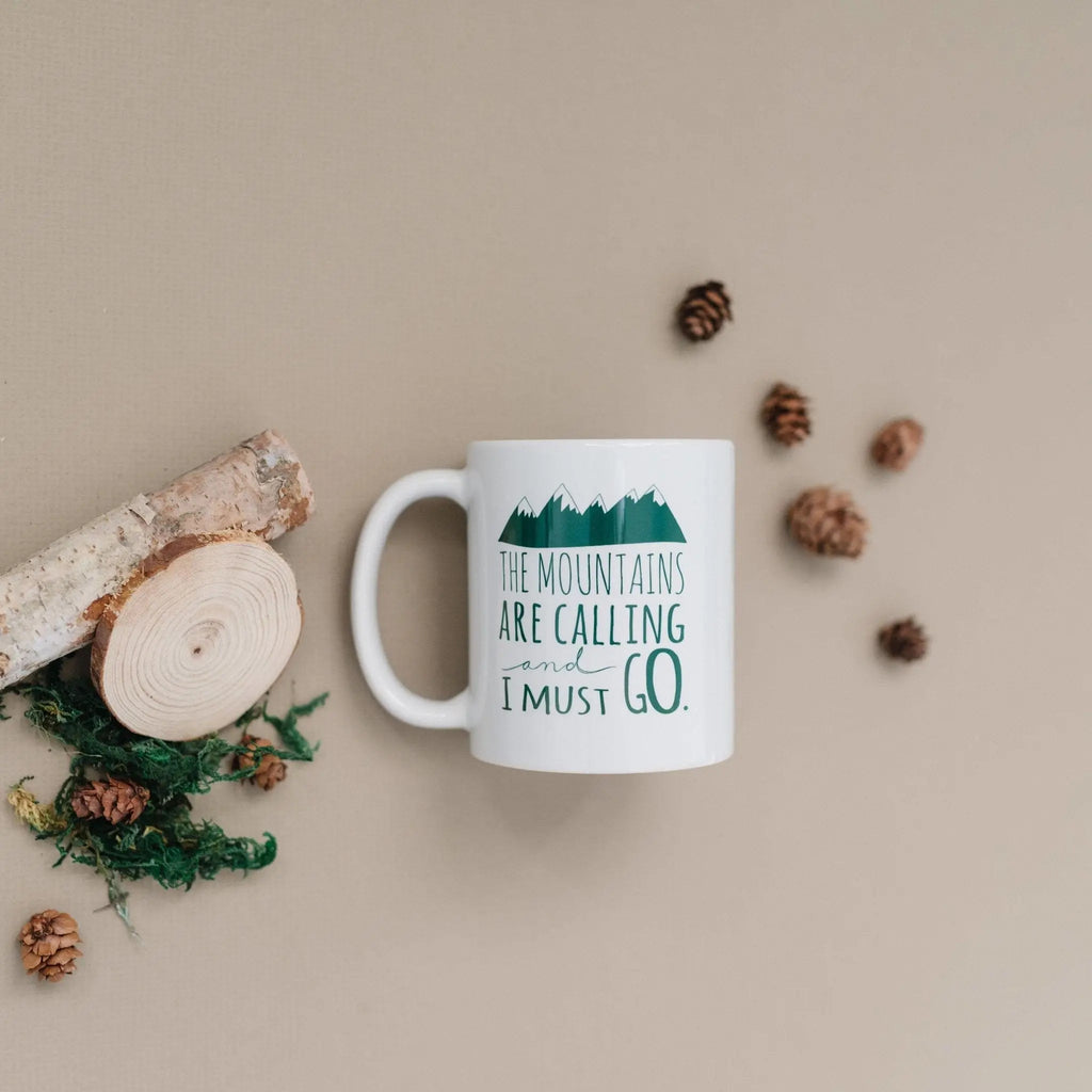 White ceramic mug with green mountain quote on front