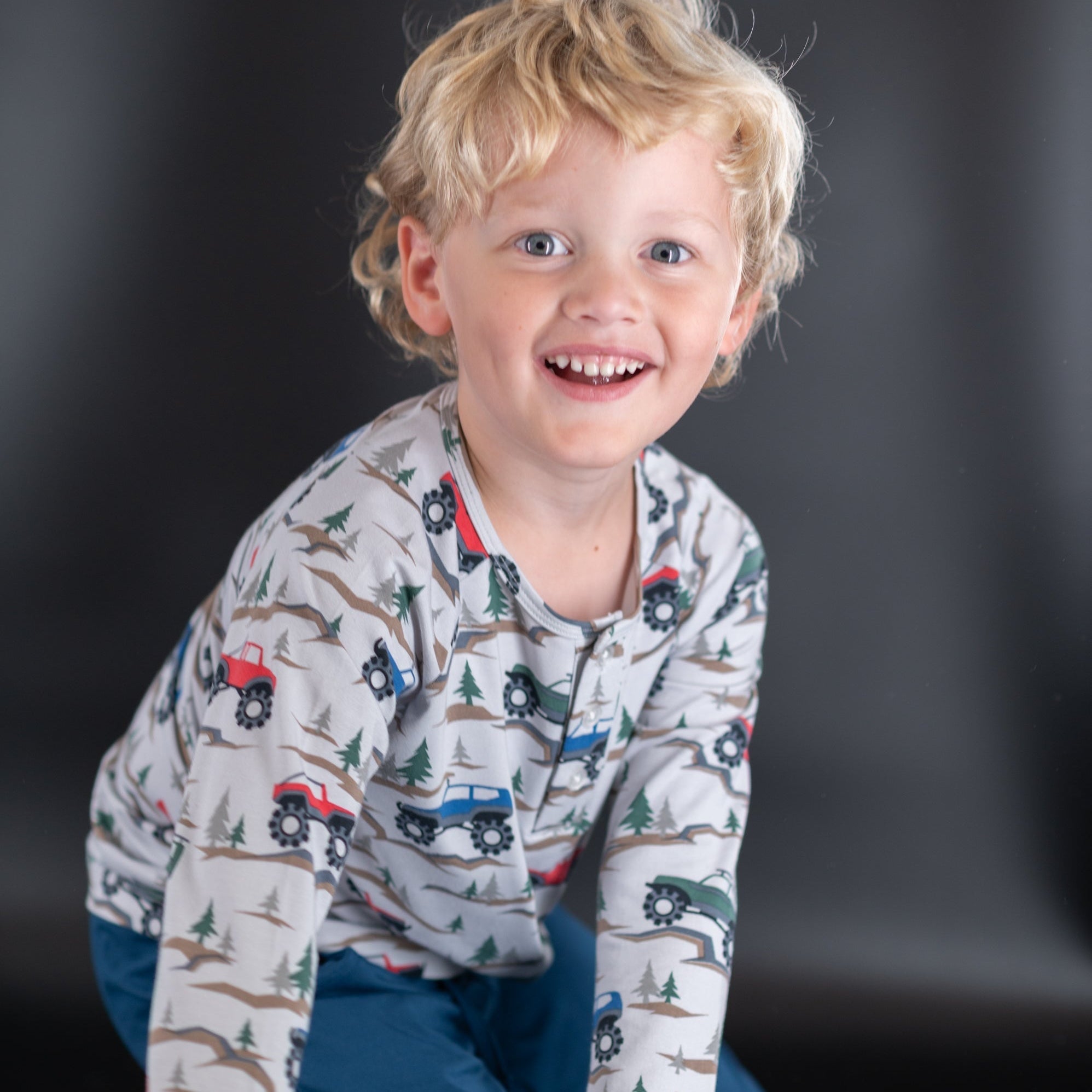 Boys raglan henley top in cream with colorful vehicle, tree and badge print, long sleeve