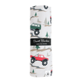 Baby swaddle blanket with forest and truck pattern, white base, green and red vehicles.