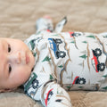 Baby zipper footie in white with colorful vehicles and evergreen tree pattern