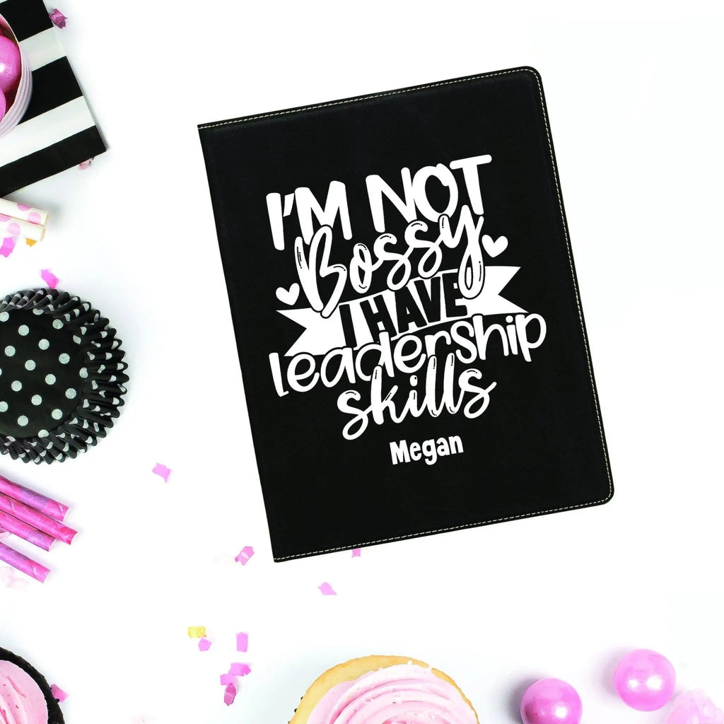 Black leather portfolio with notepad, cover text “I'm not bossy” and name Megan