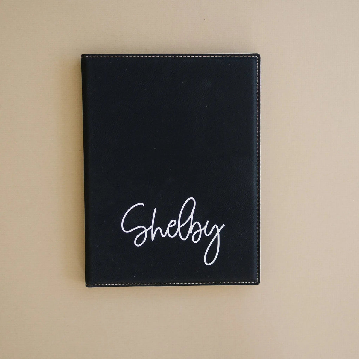 Personalized black note pad holder with cursive 'Shelby' on front