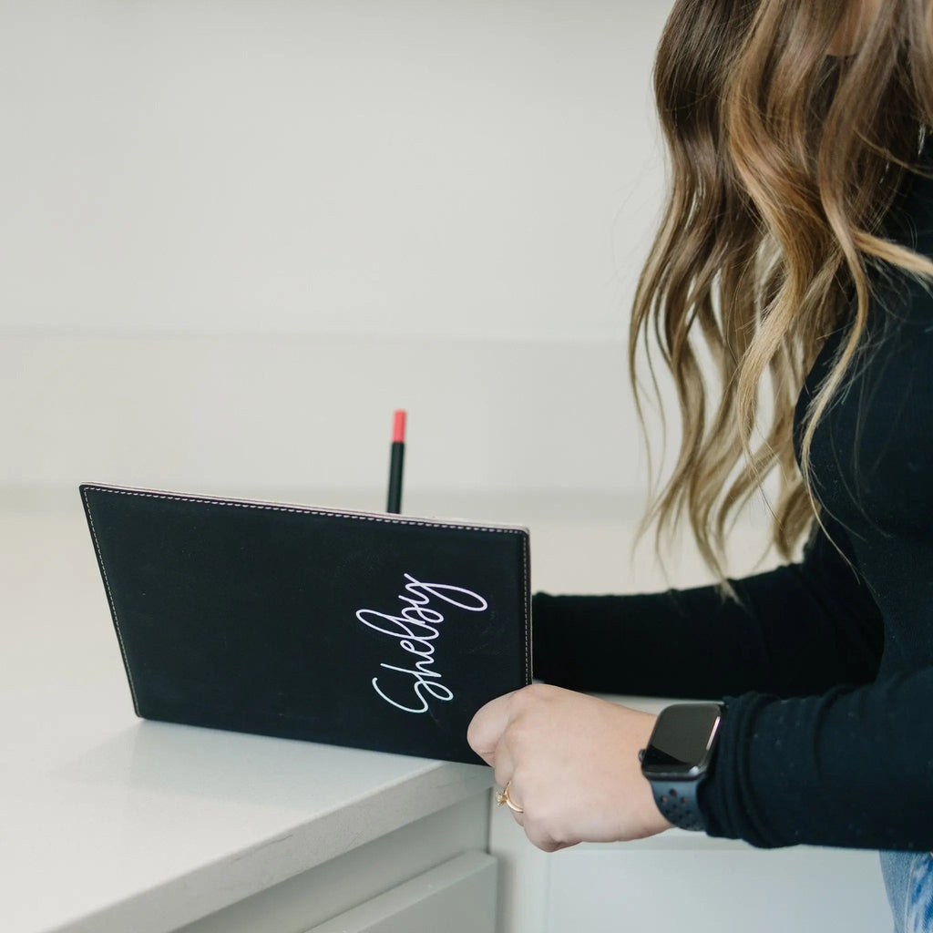 Personalized black note pad holder with cursive 'Shelby' front cover