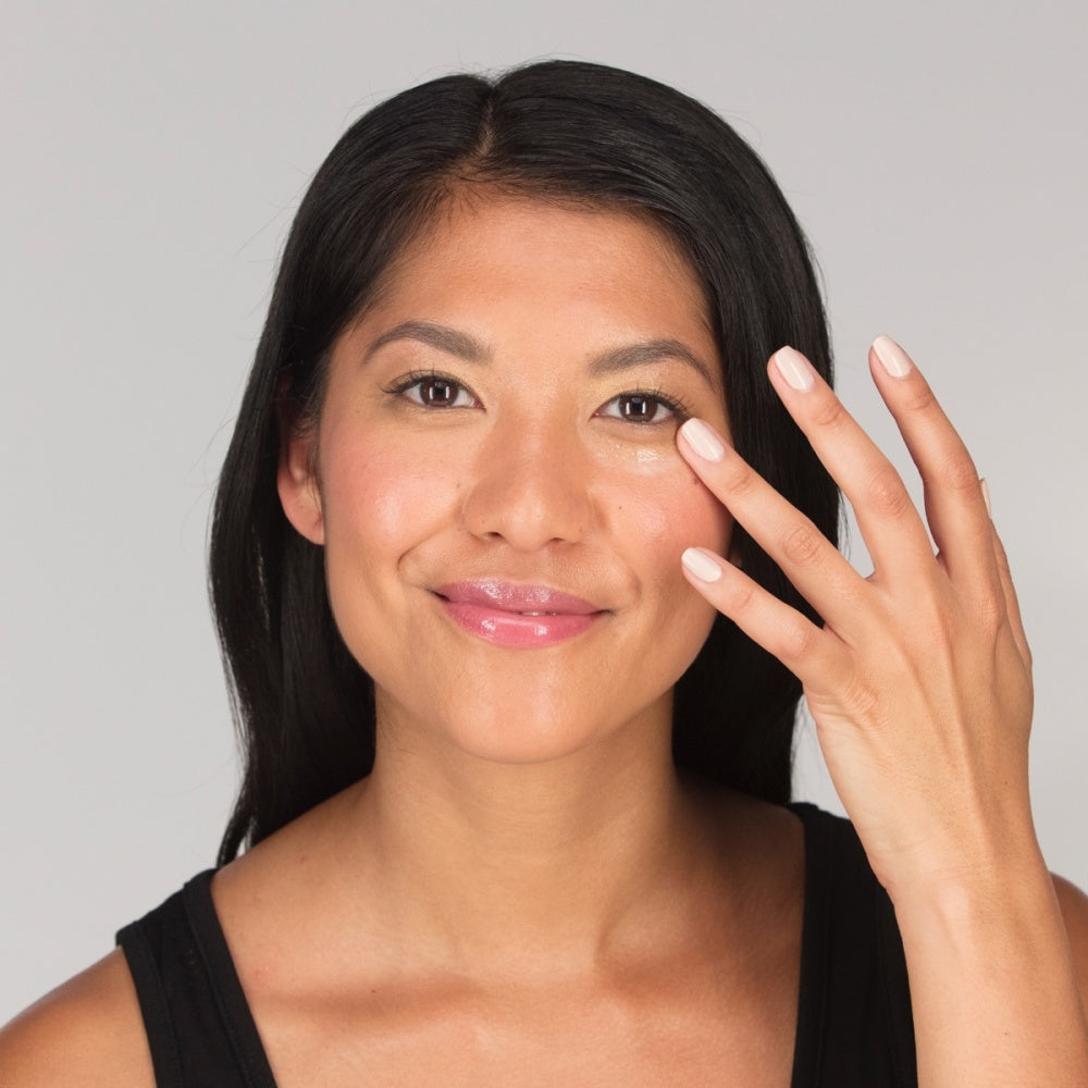 Skincare gel being applied to face; woman with manicured nails