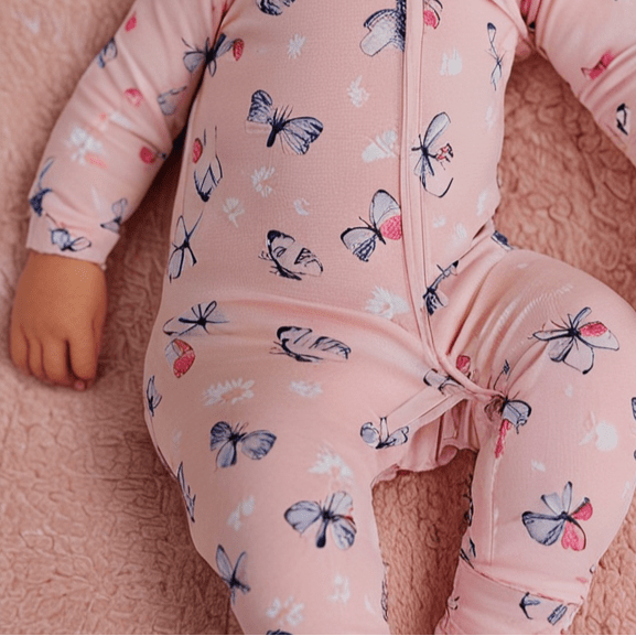 Pink bamboo zipper footie with butterfly and daisy print, front zipper visible