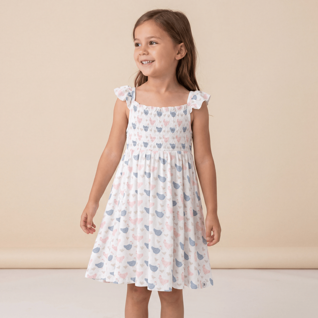 Girls' smocked vintage dress in light pink with blue hen print, ruffled cap sleeves