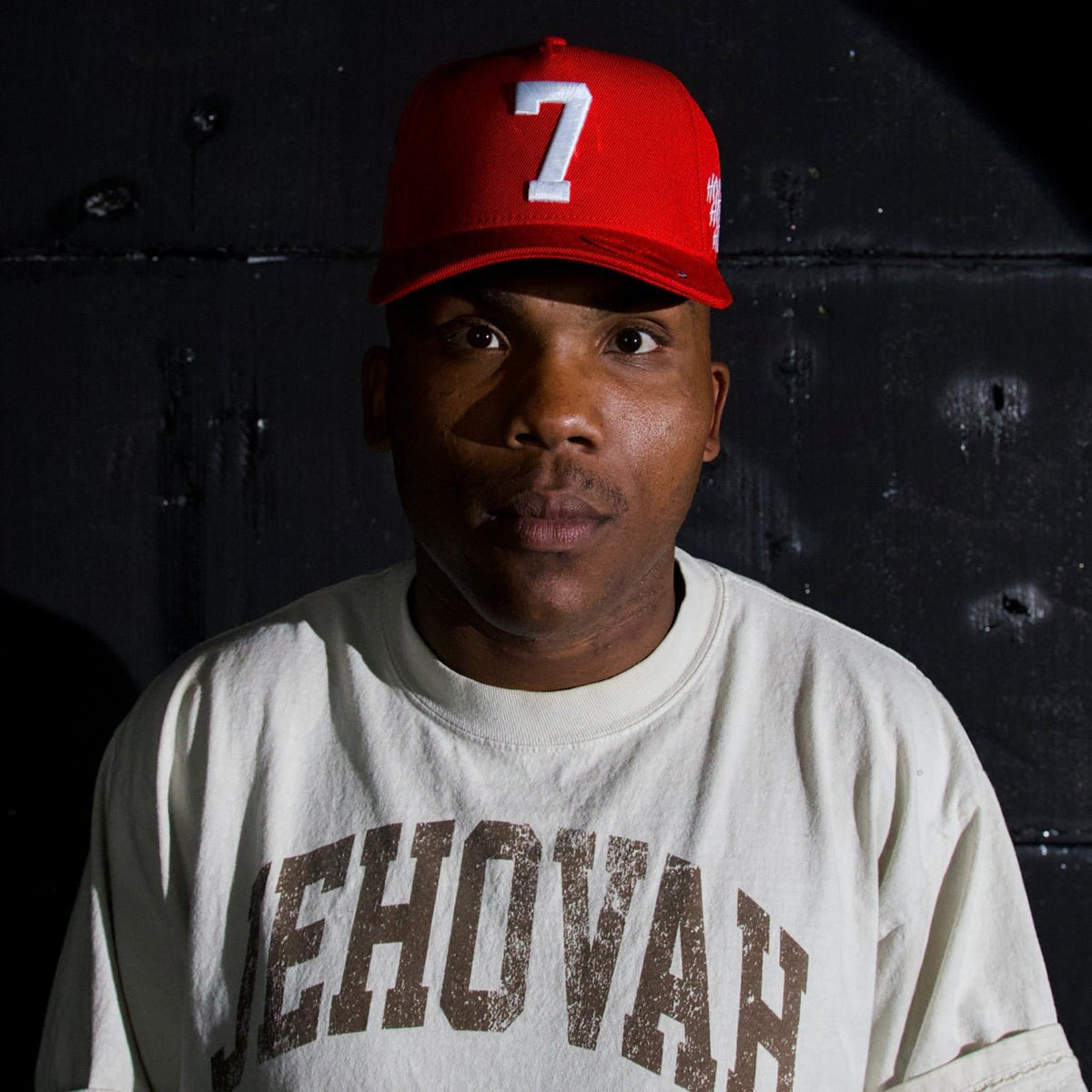 Man wearing a red snapback cap with white "7" on the front