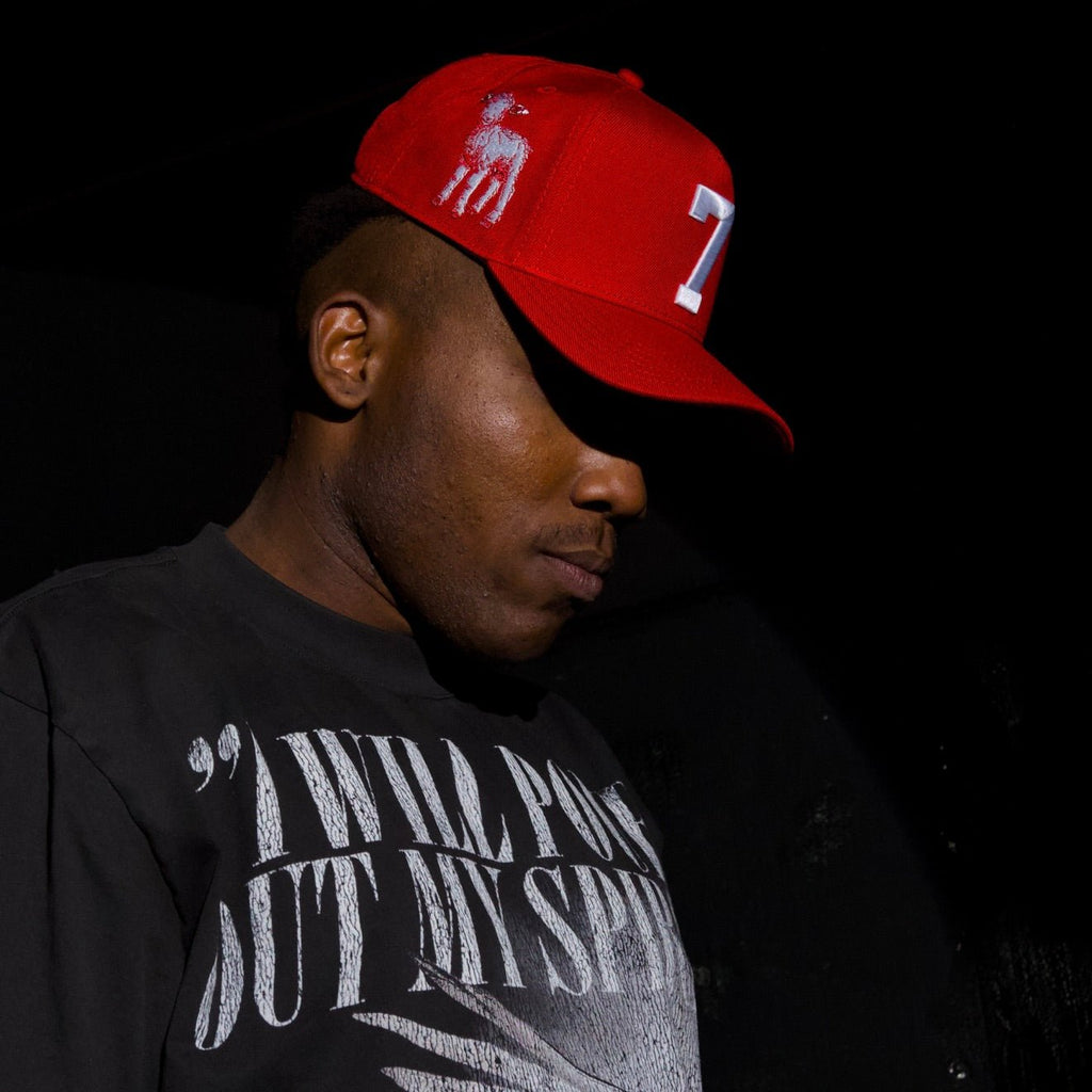 Man wearing a red snapback cap with white "7" front patch