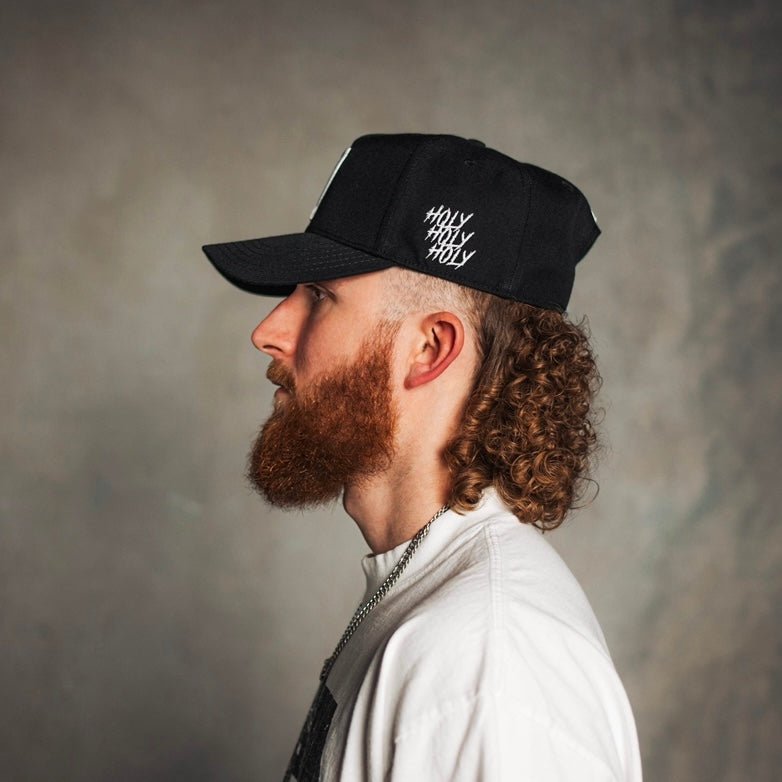 Black snapback cap with 'Holy Holy Holy' text, side view