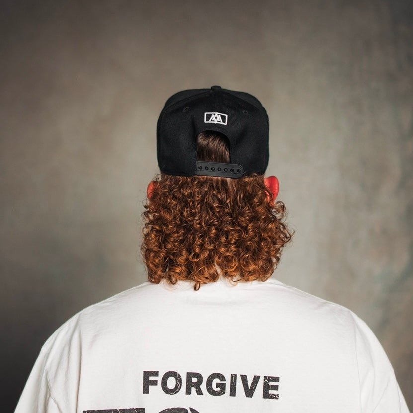 Black snapback cap with small white front emblem, back view
