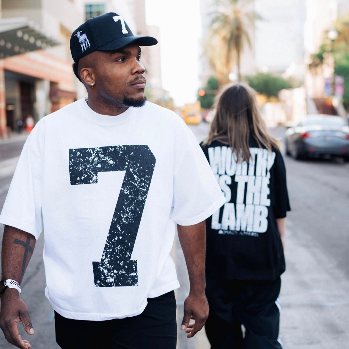 Black snapback cap with white '7' patch worn on city street