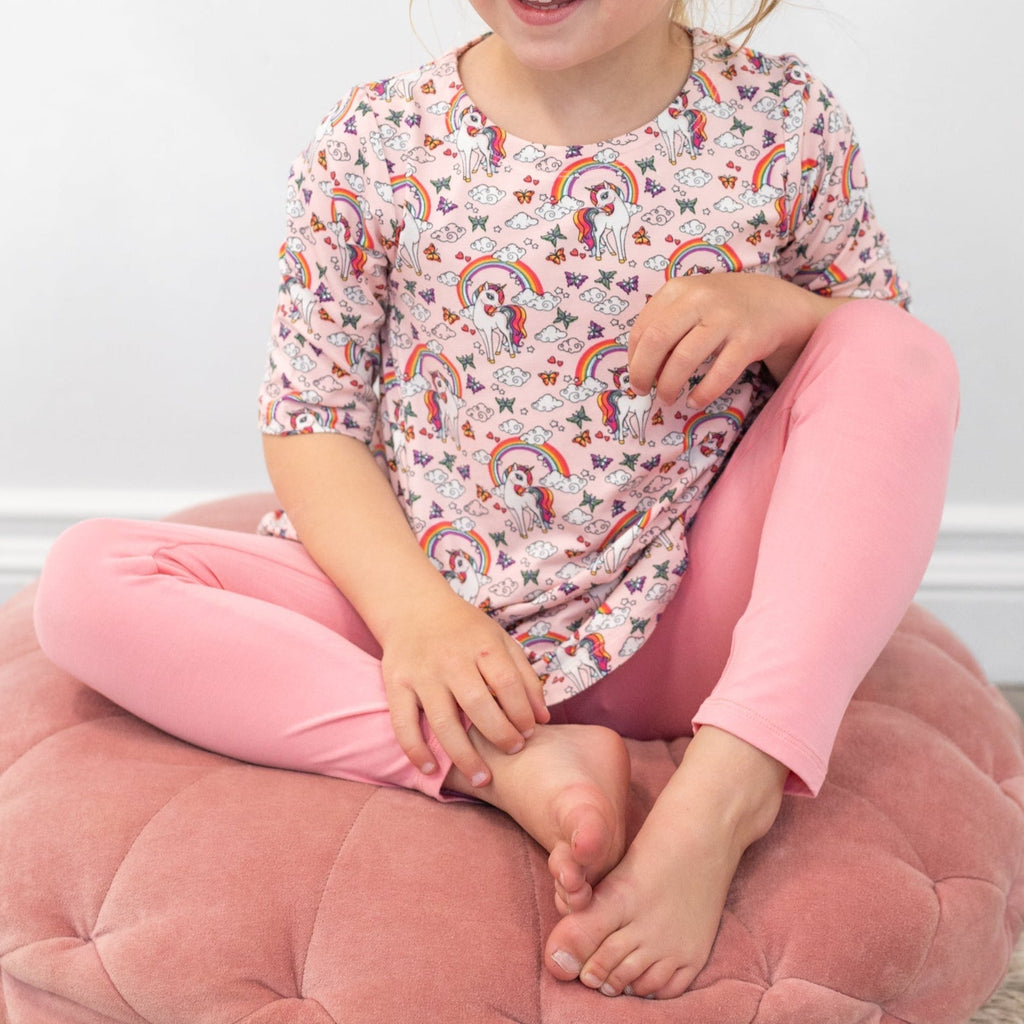 Girls tunic on model, short sleeves, crew neck; colorful unicorn and rainbow pattern