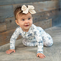 Baby long-sleeve romper with blue cowboy print on a white background and full-length legs