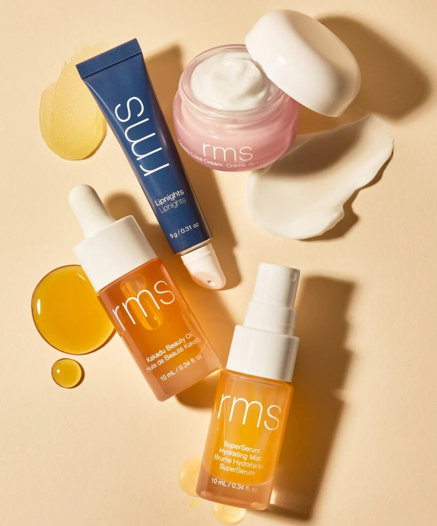 Skincare kit bottles and balm with blue tube, pink cream, and amber serum