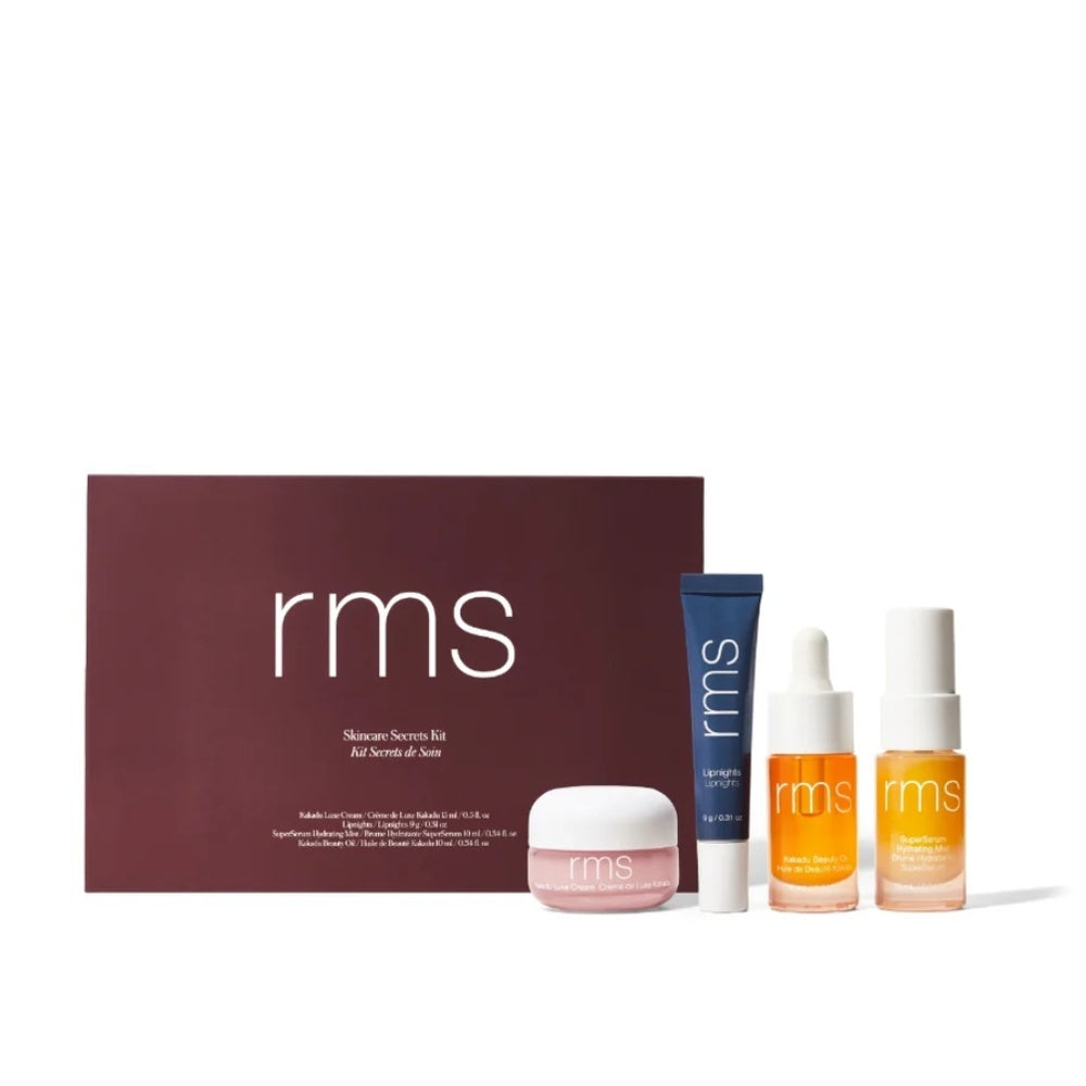 Skincare travel kit with RMS bottles and balm in a branded box