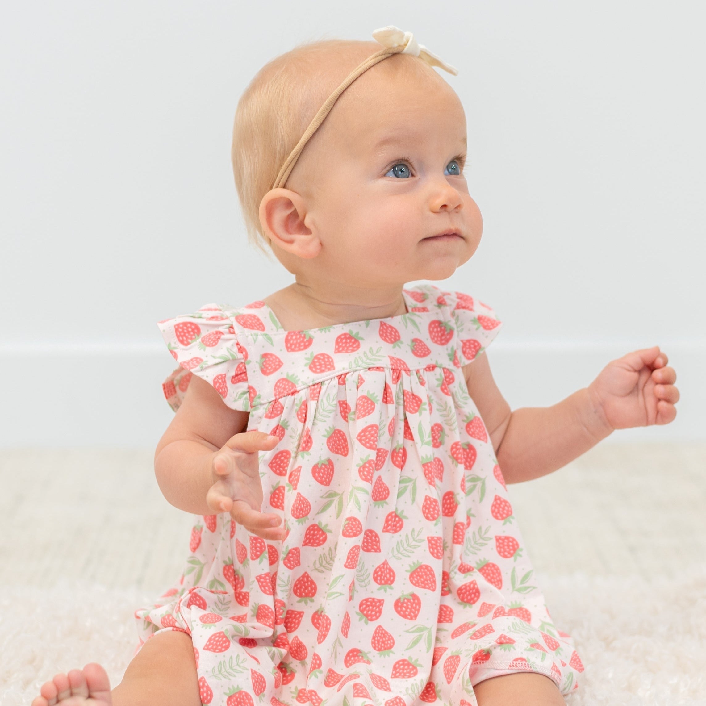 Girls ruffle dress in strawberry print with bow-like ruffled shoulders