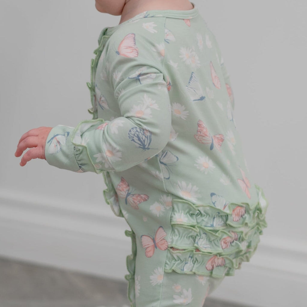 Mint baby footie with ruffled leg cuffs and butterfly-and-daisy print, side view