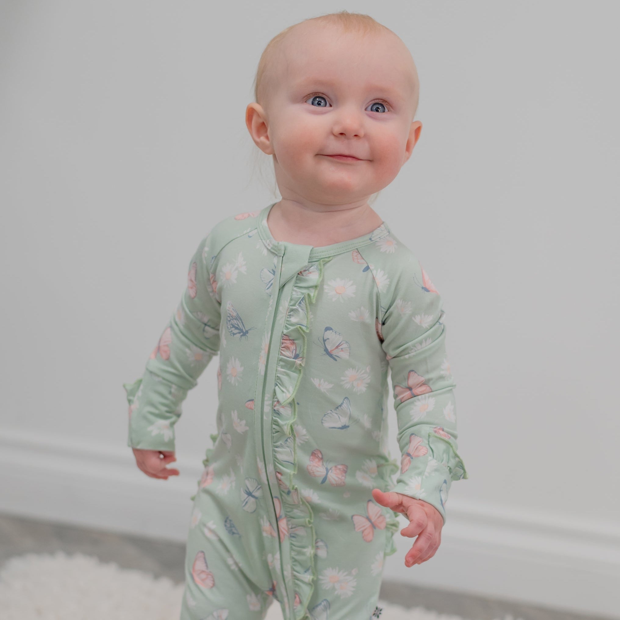 Mint baby footie with front zipper and ruffled cuffs, butterfly and daisy print
