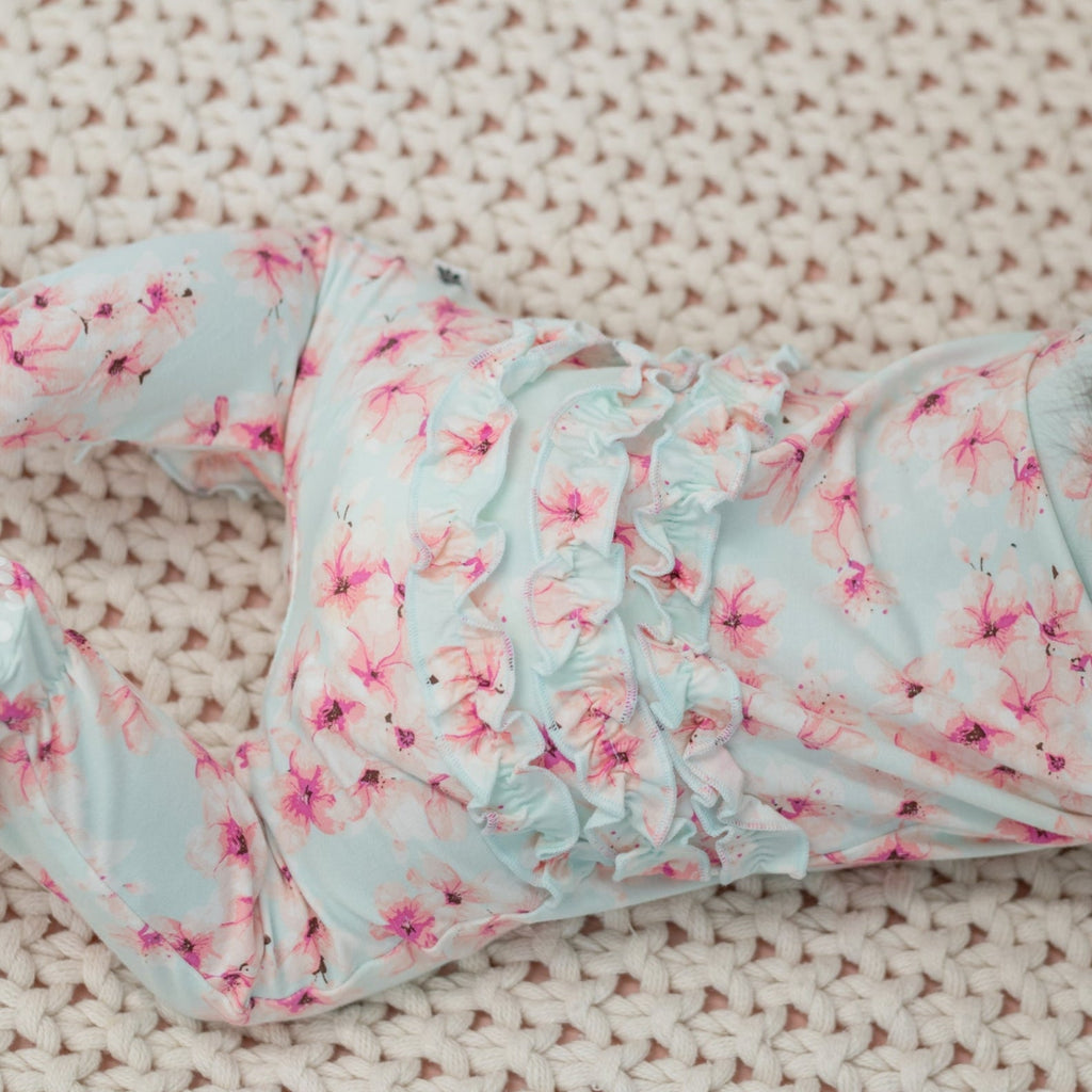 Blue floral ruffle footie with gathered neckline and cuff details