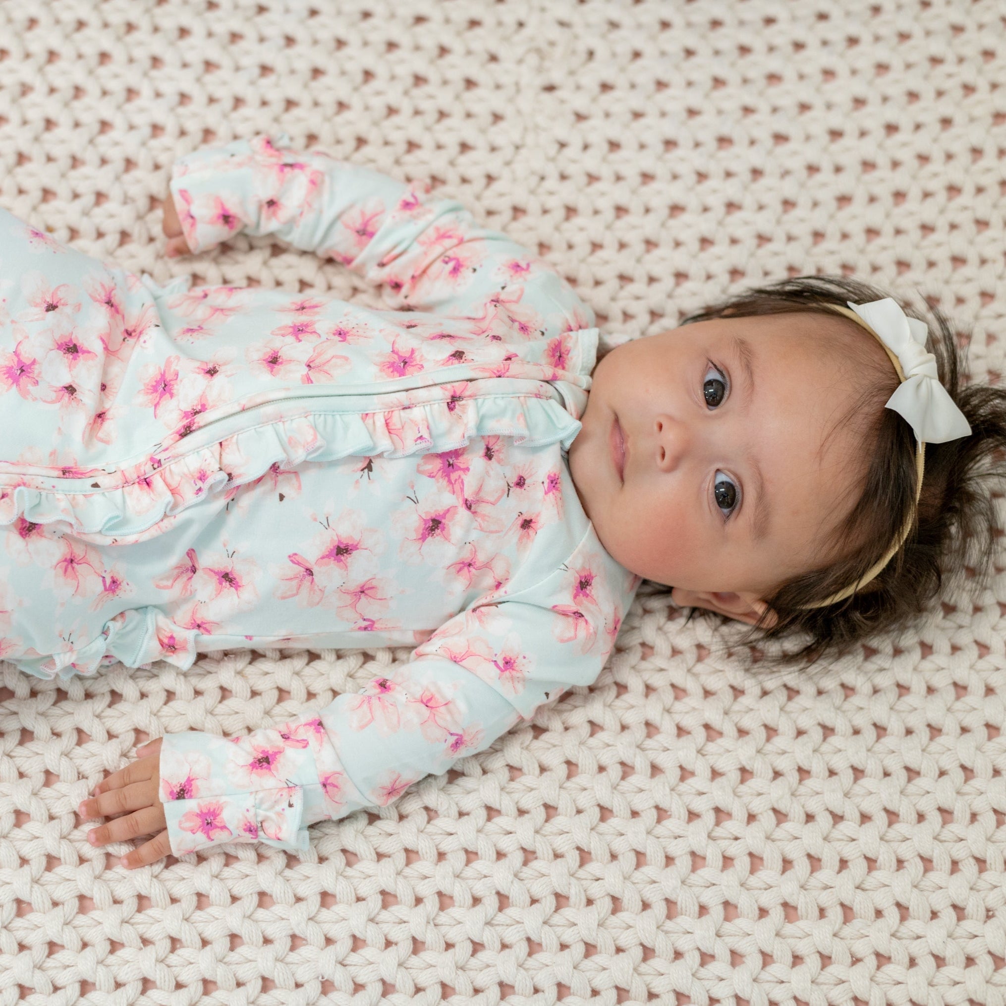 Blue floral ruffle footie with long sleeves and zip front