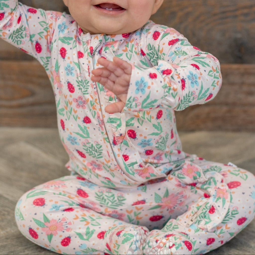 Baby footie pajamas with ruffle collar, colorful floral ladybug print, zip front