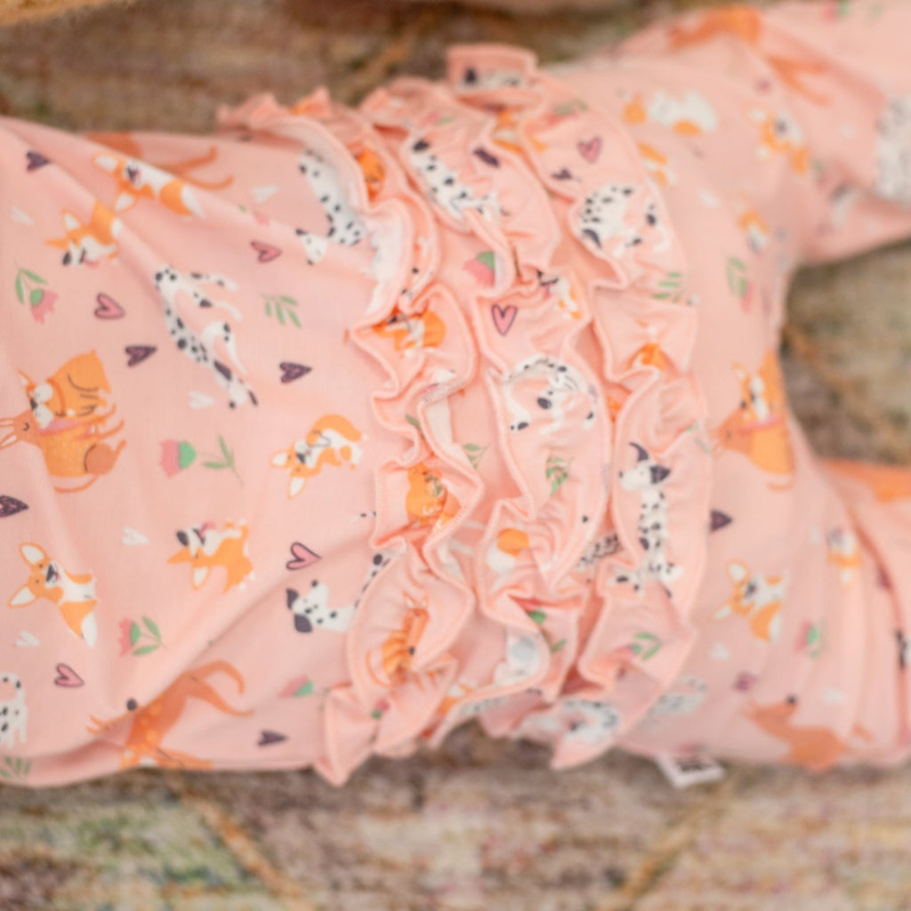 Pink animal-print ruffle footie fabric close-up with soft gathered details