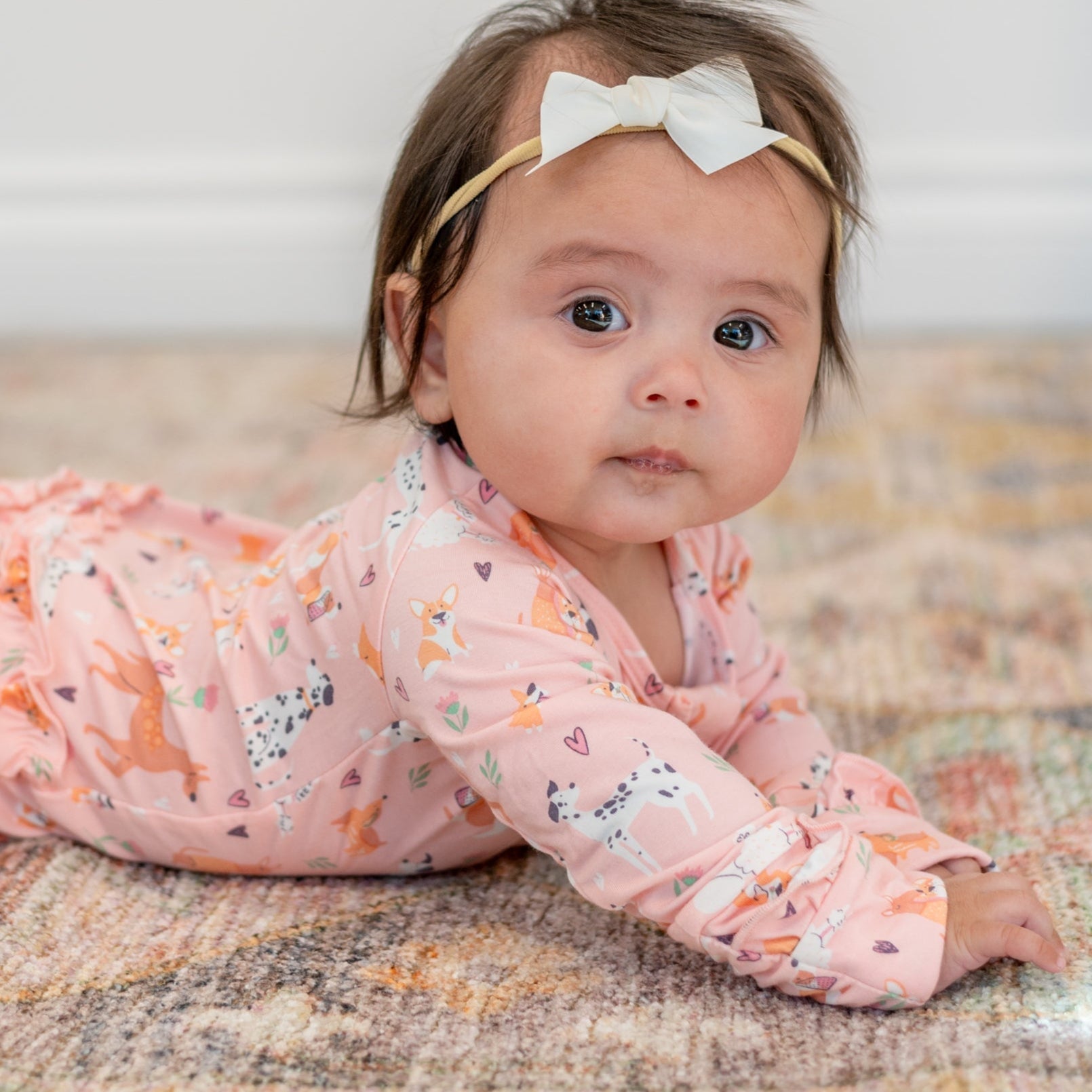 Pink long-sleeve animal-print footie with soft ruffle neckline
