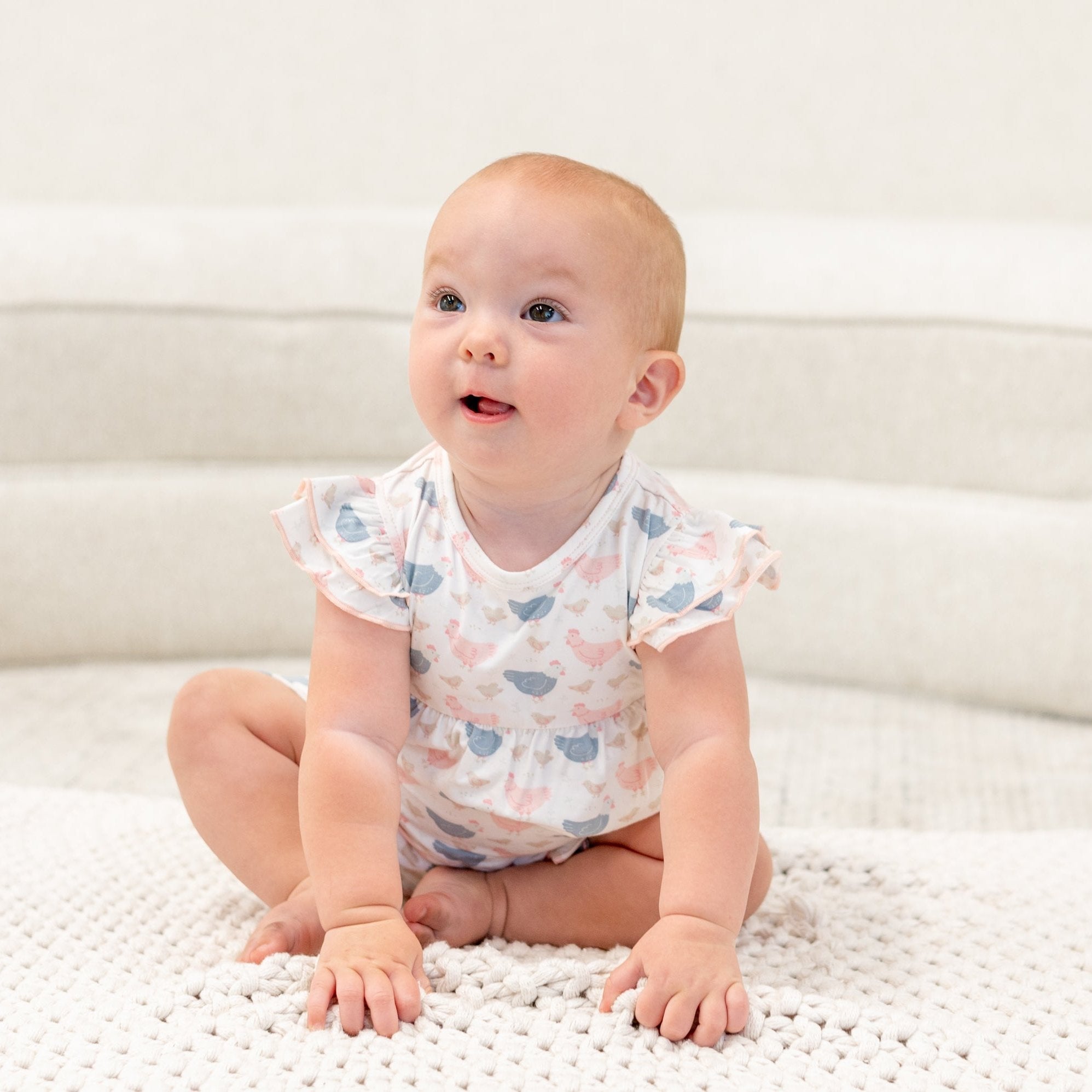Pastel bird print baby romper with ruffled sleeve details and scoop neckline