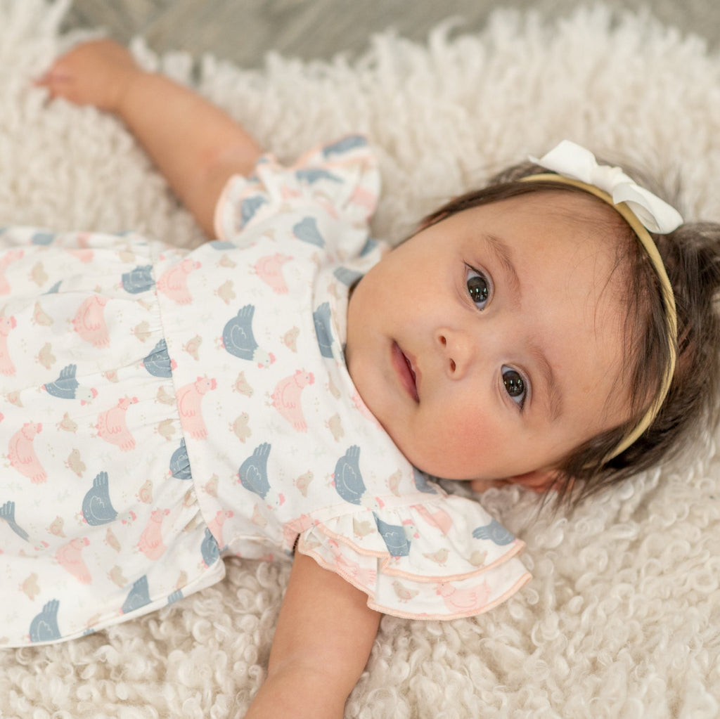 Baby romper with pastel birds, ruffled sleeves, and pink and blue accents