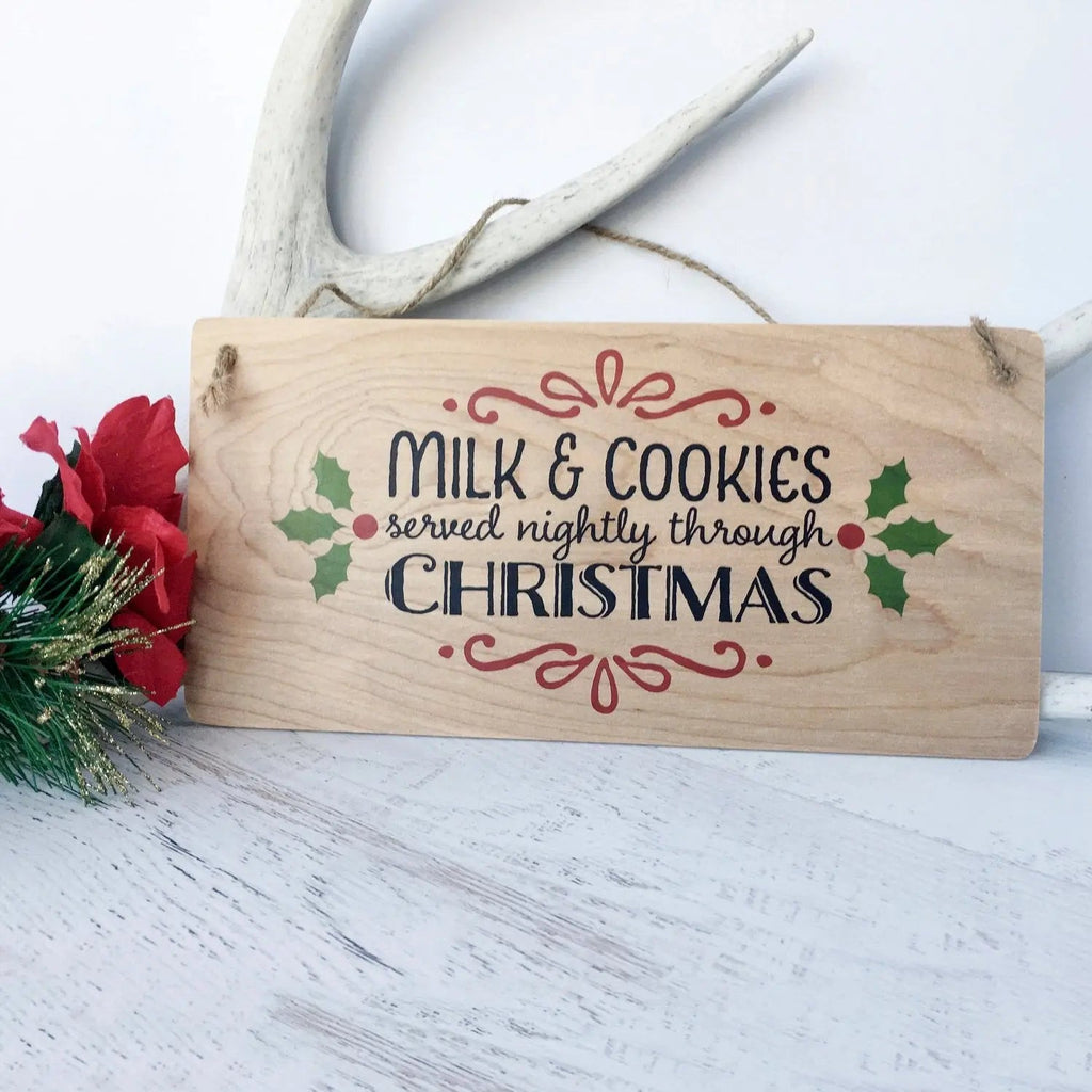 Hanging wooden sign reading Milk & Cookies served nightly through Christmas