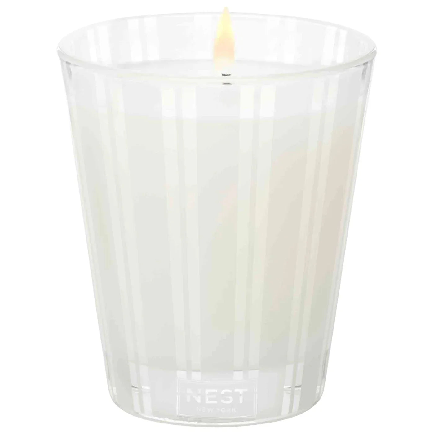 Grapefruit NEST candle in clear glass tumbler with single flame and NEST logo