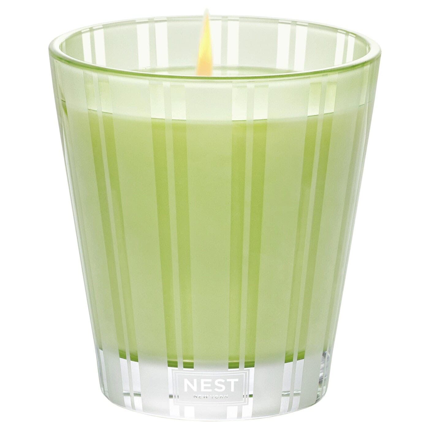 Light green glass candle with NEST label and visible wick flame