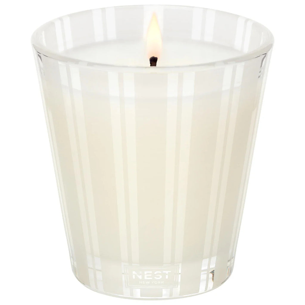 Scented candle in clear ribbed glass with lit wick, Madagascar Vanilla