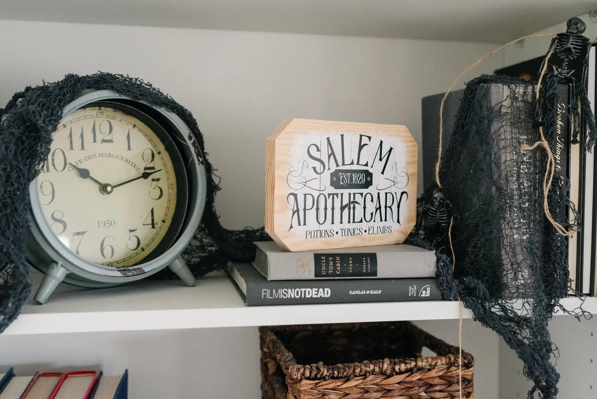 Octagonal wood block sign reading 'SALEM APOTHECARY' with small subtext